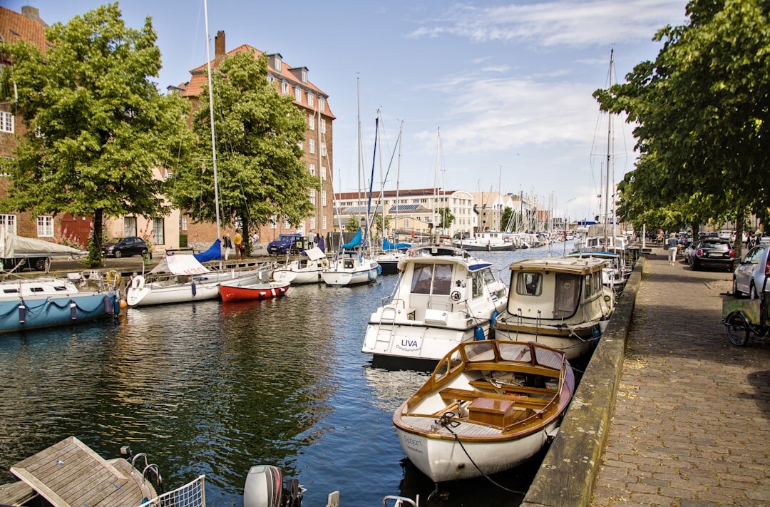 Elderly Danish fisherman mending nets on the harbor
